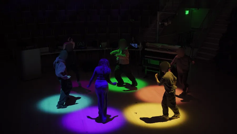 Dancers in an Encypher cypher during the public live performance, each standing in a colored pool of light on their zone