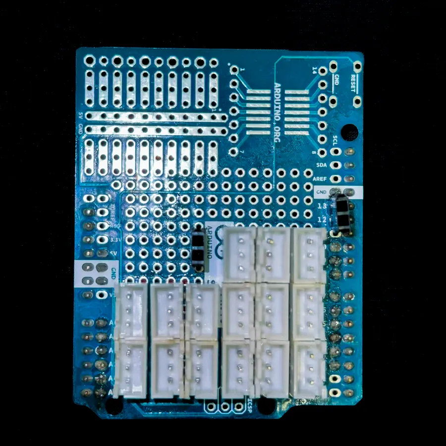An Arduino proto shield with fifteen white 3-pin JST sockets in rows