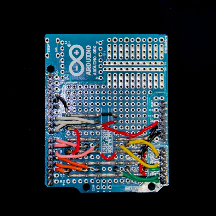 The underside of the Arduino proto shield, hand-wired with coloured jumper wires